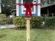 The blue and white little library with a red bow around it.